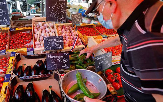 Một khách hàng mua thực phẩm tại chợ địa phương ở TP Nice - Pháp hôm 7-6. Ảnh: REUTERS