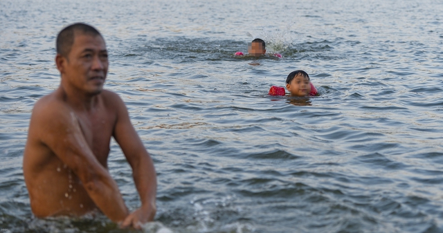  Giữa trời nắng chang chang, bất chấp biển cấm, người dân đội nón bơi ra giữa hồ Linh Đàm - Ảnh 7.