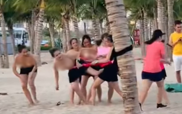 Nhóm phụ nữ để ngực trần chơi team building ở bãi biển Hạ Long
