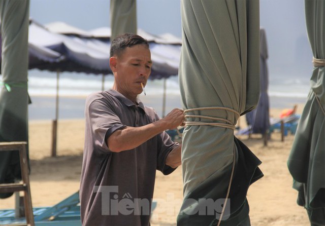 Người dân Đà Nẵng thu dọn hàng quán, hối hả xếp dù trên bãi biển chạy bão - Ảnh 1.