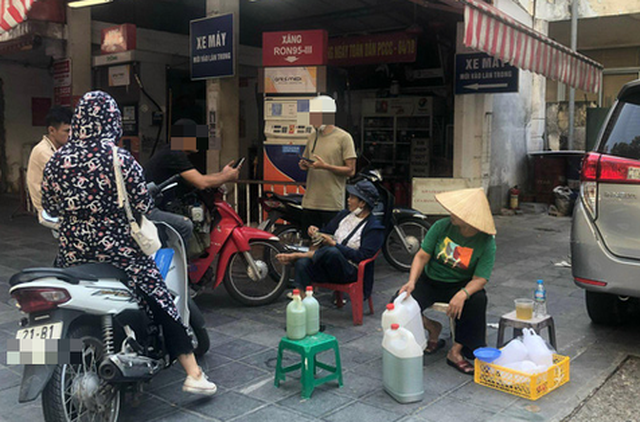 Ảnh hai người phụ nữ mang các can xăng lẻ ra bán ngay trước cây xăng số 4 Nguyễn Đình Chiểu (Hai Bà Trưng, Hà Nội) vào thời điểm hơn 16h30 ngày 6-9 - Ảnh: C.T.V
