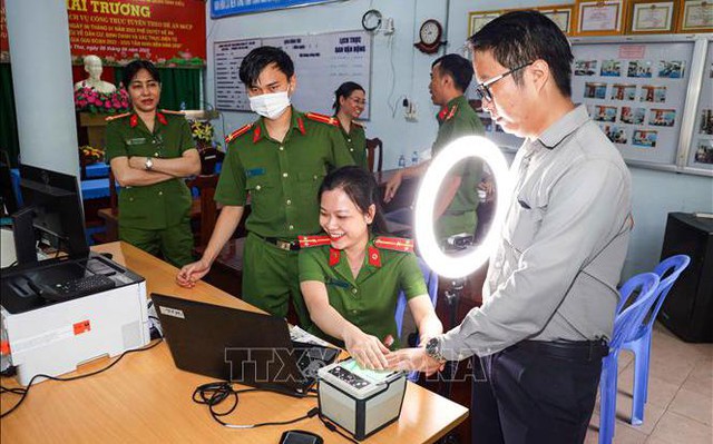 Cán bộ Công an phường Tân An, quận Ninh Kiều hướng dẫn người dân thực hiện đăng ký tài khoản định danh điện tử mức độ 2. Ảnh: TTXVN phát