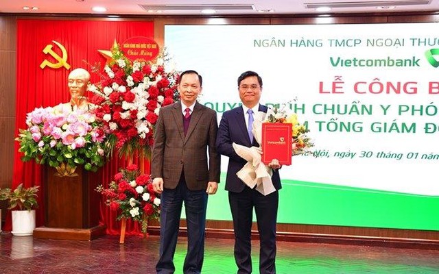 Ông Đào Minh Tú - Phó Thống đốc Thường trực NHNN (bên trái) tặng hoa chúc mừng ông Nguyễn Thanh Tùng