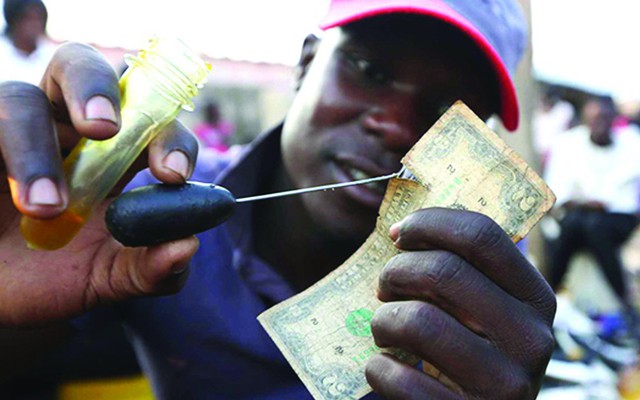 Nghề “vá tiền” rách đang trở thành kế sinh nhai cho nhiều người ở Zimbabwe.