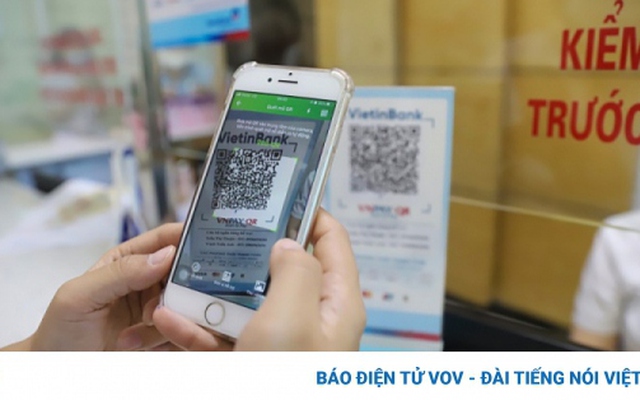 Người dân thanh toán dịch vụ y tế tại tại thành phố Hạ Long (Quảng Ninh) bằng cách quét mã QR của ngân hàng trên điện thoại thông minh.