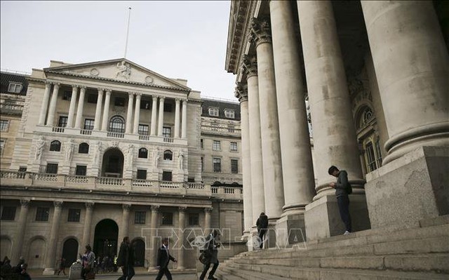 Quang cảnh bên ngoài trụ sở Ngân hàng Trung ương Anh (trái) ở London. Ảnh: AFP/TTXVN