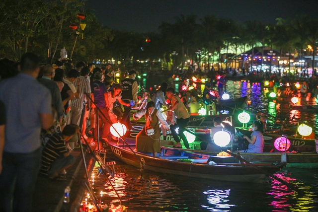 Tourists walk around Hoi An ancient town, waiting in long queues to drop flower lanterns on Tet holiday - Photo 8.