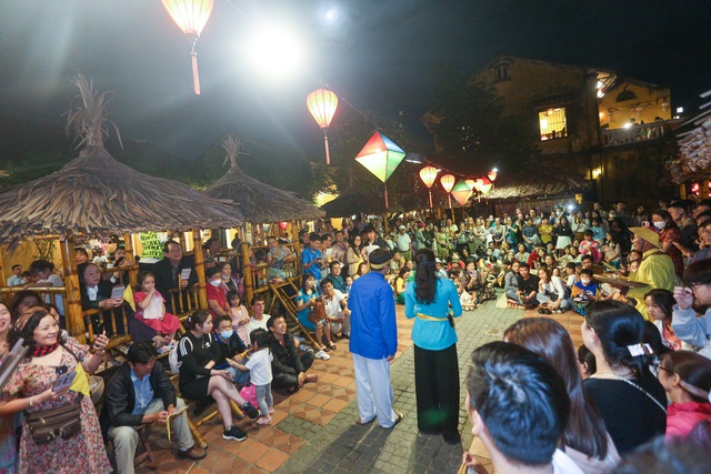 Tourists walk around Hoi An ancient town, waiting in long queues to drop flower lanterns on Tet holiday - Photo 14.