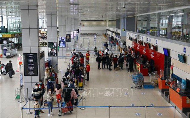 Hành khách làm thủ tục lên chuyến bay tại sảnh E sân bay Nội Bài. Ảnh tư liệu: Huy Hùng/TTXVN