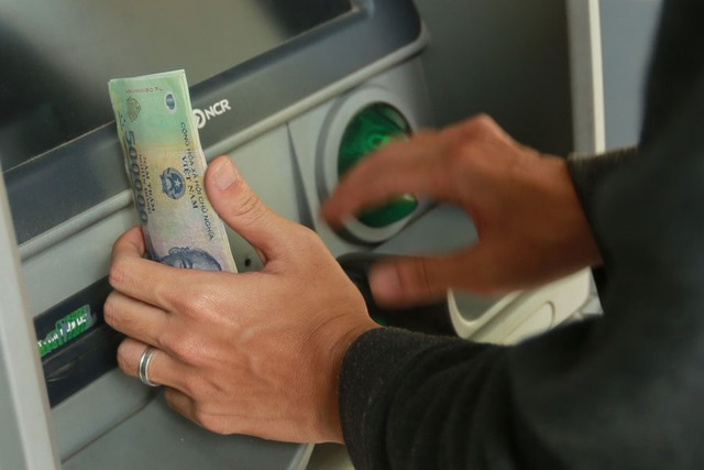 Cao điểm cận Tết vẫn ít người dân rút tiền mặt qua ATM - Ảnh 1.