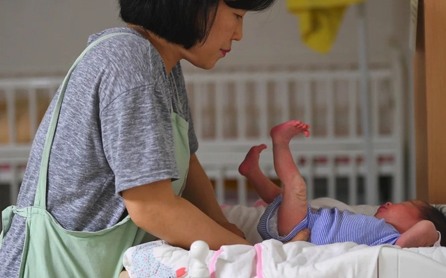 Nhân viên xã hội đang chăm sóc một em bé tại Nhà thờ Cộng đồng Jusarang ở phía nam Seoul. Ảnh: AFP