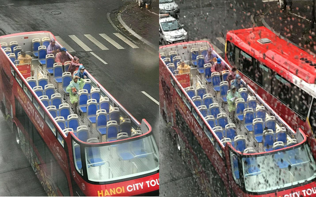 Hành khách mặc áo mưa trải nghiệm du lịch Hà Nội trên xe bus 2 tầng