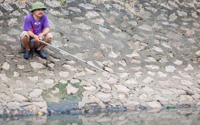 Người dân thư thả ngồi câu cá bên bờ sông Tô Lịch
