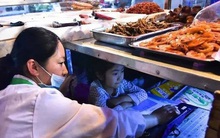 Câu chuyện của bé gái 7 tuổi ngồi học dưới gầm sạp hàng của mẹ: Phía trên là cuộc sống mưu sinh, bên dưới là hy vọng