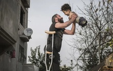 Chuyện đau lòng sau "Bức ảnh của năm": Cha chống nạng nâng niu con chẳng lành lặn, đớn đau cùng cực vẫn quyết mang đôi chân về cho con