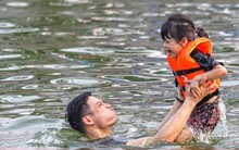 Trời nắng, phụ huynh đưa con nhỏ ra bơi ở ao làng
