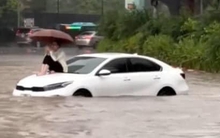 Danh tính cô gái leo lên nóc capo, ung dung ngồi giữa "biển nước" ở Hà Nội sáng nay