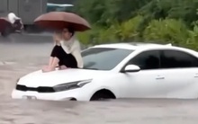 Đường Hà Nội có nơi ngập gần 1m trong sáng nay, người dân ngồi lên nóc xe chờ nước rút