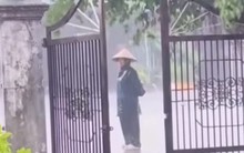 Bức ảnh người phụ nữ đội mưa đứng trước cổng nhà khiến netizen nhòe nước mắt