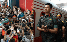 Thượng úy Lê Hoàng Hiệp được các chiến sĩ khác “hộ tống” di chuyển ra khỏi vòng vây của đông đảo người dân tại ga Hà Nội