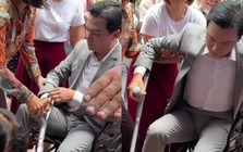 Mạnh Quỳnh về Việt Nam, phải ngồi xe lăn và chống nạng