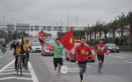 Chùm ảnh: Người hâm mộ cầm cờ Tổ quốc, chạy bộ ra sân bay Nội Bài để đón U23 Việt Nam