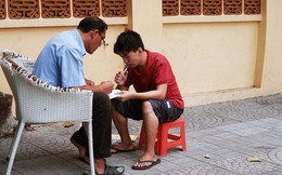 "Lớp học" đáng yêu trên vỉa hè: Một bác bảo vệ vừa giữ xe vừa dạy chữ cho cậu nhóc bán hàng rong ở Sài Gòn