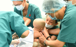 2 bé song sinh Diệu Nhi - Trúc Nhi đã bớt sốt, các bác sĩ tiến hành chuyển bé qua nệm chống loét, nhiễm trùng