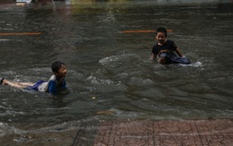 Trẻ em bơi giữa đường phố Sài Gòn sau cơn mưa lớn