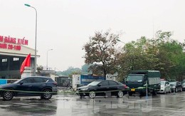 Người dân xếp hàng dưới mưa chờ đăng kiểm ô tô tại Hà Nội
