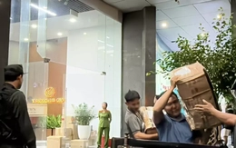 Cảnh sát vận chuyển nhiều thùng niêm phong ra khỏi tòa nhà có trụ sở công ty Shark Bình