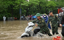 Ảnh đẹp sáng nay: Các chiến sĩ làm nhiệm vụ A80 lội nước đẩy xe, dìu dân qua đoạn ngập sâu ở Hà Nội