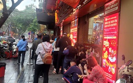 Người dân đội mưa xếp hàng chờ mua vàng trước ngày vía Thần Tài