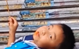 Mẹ đến đón muộn, cậu bé thản nhiên nằm trên bậc thềm ăn đồ ăn: Dân mạng bật cười vì quá chill!