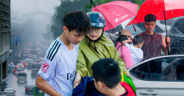 Hà Nội đang nắng gắt bỗng tối sầm, mưa như trút nước giữa trưa khiến người đi đường không kịp trở tay